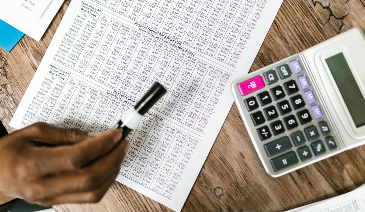 Tax documents and a calculator on a wooden table