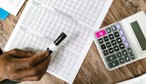 Tax documents and a calculator on a wooden table