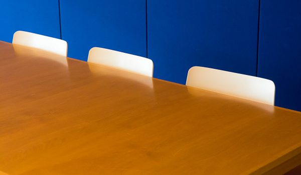 An empty meeting room with a bare wooden table