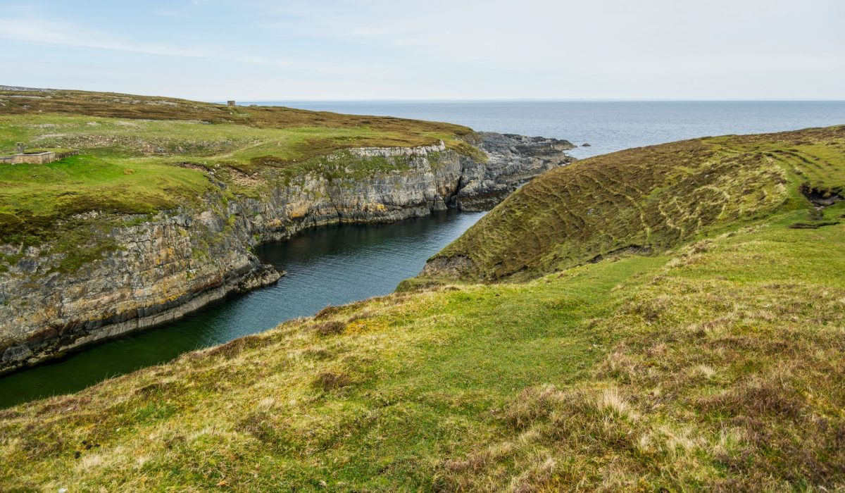 Idyllic view of coastal cliffs and grasslands in Scotland, showcasing natural beauty and t