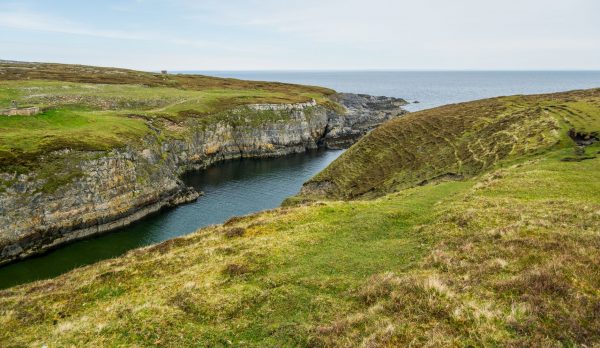 Idyllic view of coastal cliffs and grasslands in Scotland, showcasing natural beauty and t