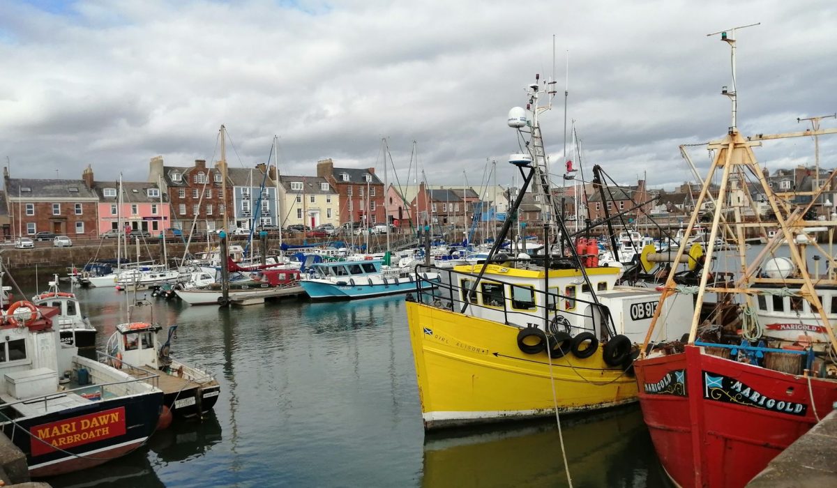 Colorful fishing boats docked in the picturesque Arbroath harbour, Scotland