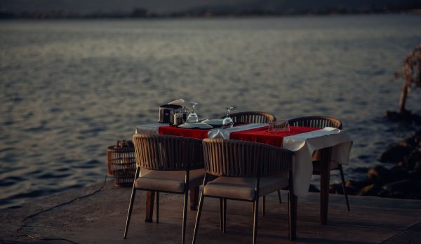A dining table set by the sea at sunset