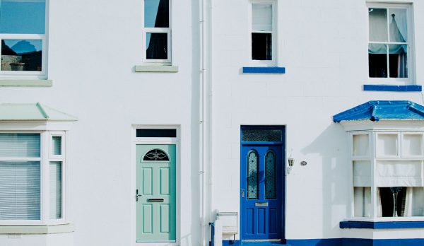 Freshly painted blue and green doors on a white house
