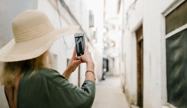 A visitor photographing an old stone building