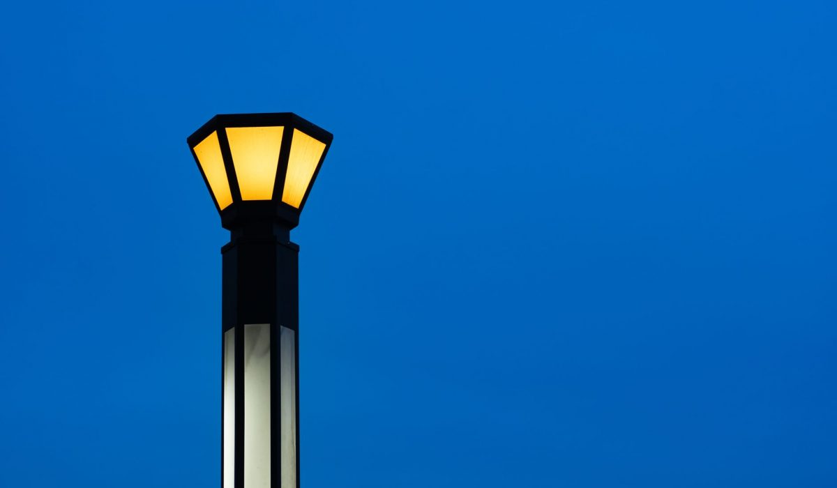 A single lit streetlamp against an evening sky