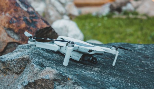 A grounded drone resting on a rock