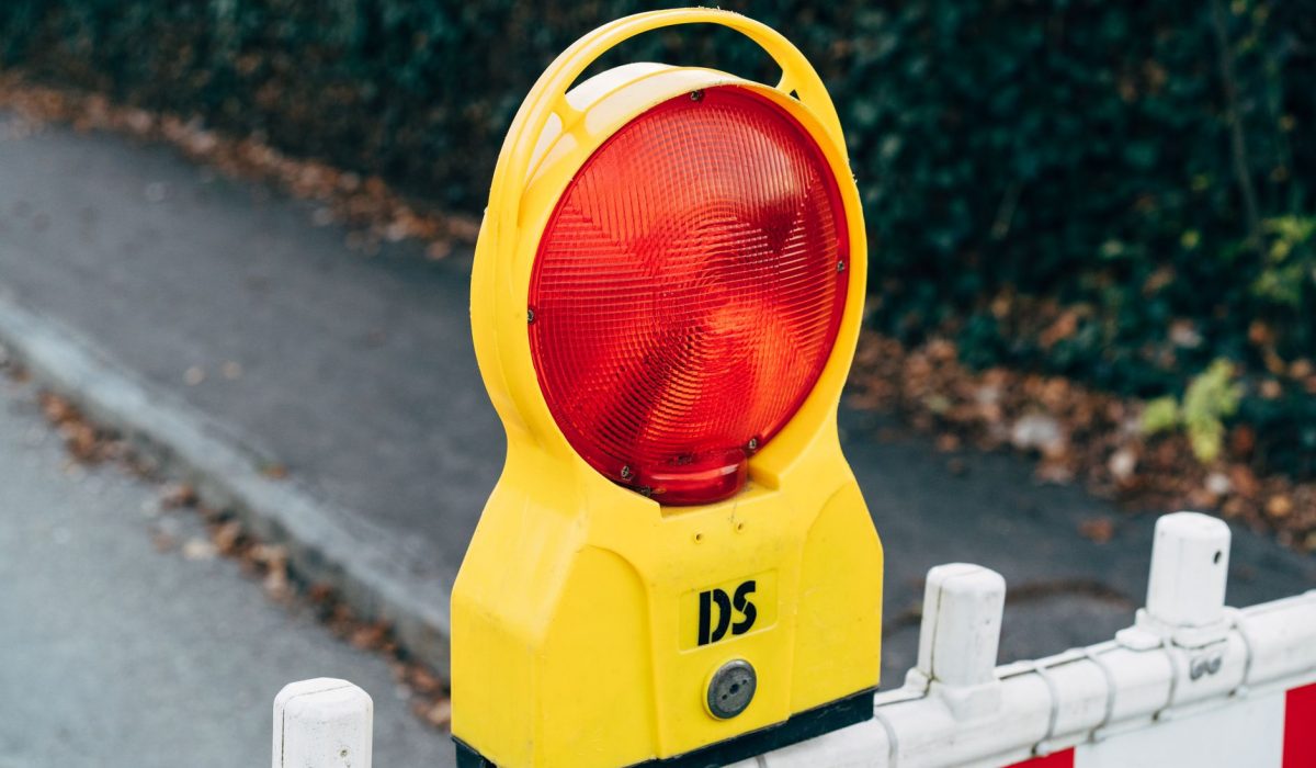A red warning light on a roadworks barrier